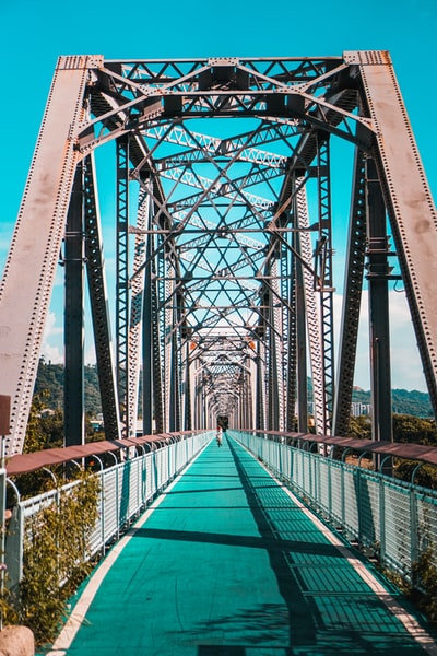 Building green metal bridge on the river during the day
